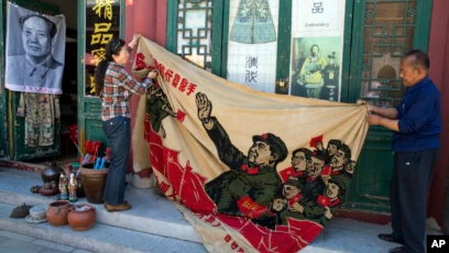 北京古玩市场展示文革时期毛泽东宣传画，历史资料图｜来源：Voice of America