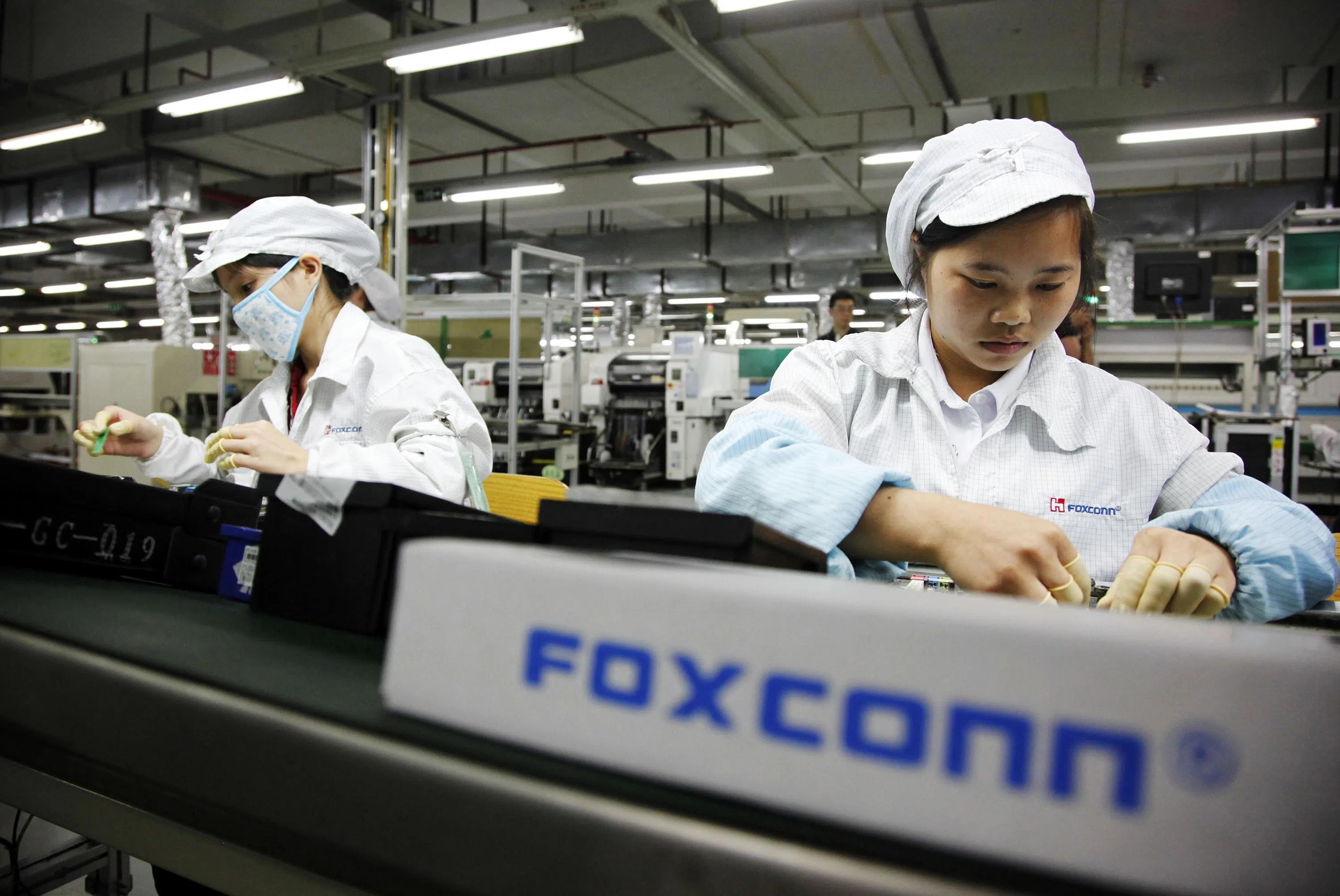 富士康工厂电子装配线工人资料图|来源:The Business Times
