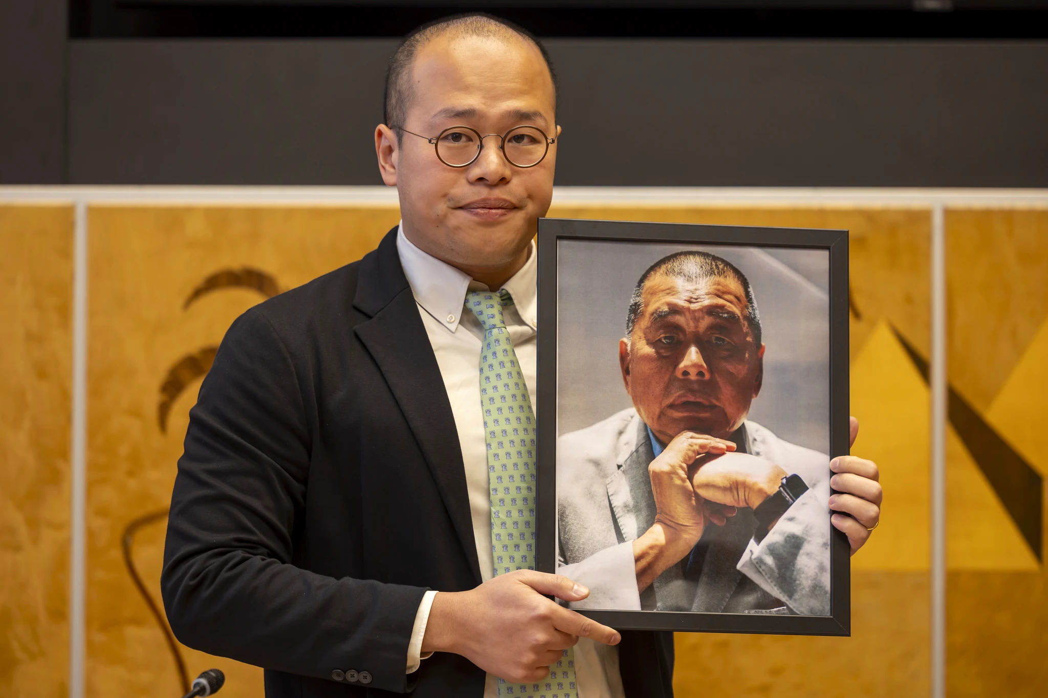 资料图:Sebastien Lai手持父亲黎智英照片。父亲被监禁后,他长期在海外为黎智英案件发声|来源:The Asahi Shimbun / AP