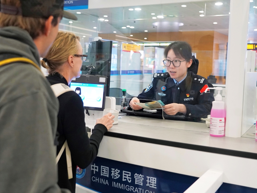 资料图:上海浦东国际机场边检人员查验旅客证件。边检是限制出境决定最终落地执行的口岸环节之一|来源:东方财富/公开报道