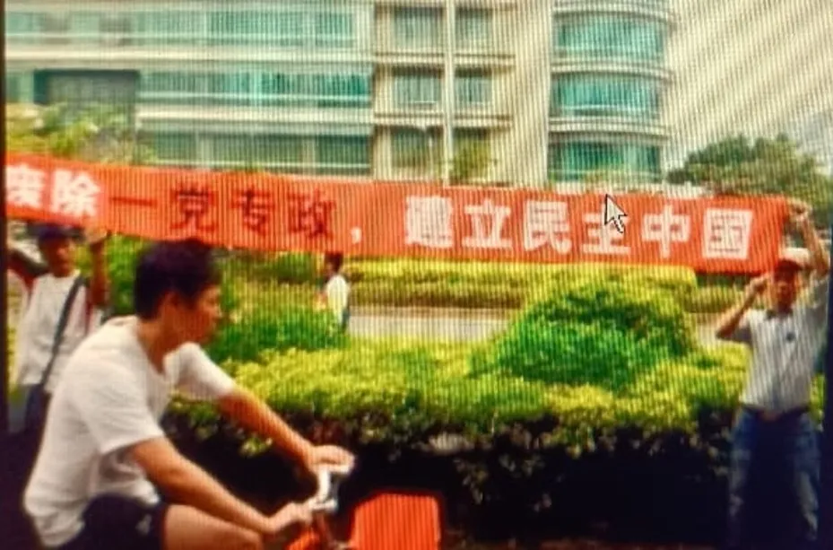 陈剑雄相关历史报道中的民主诉求街头横幅资料照;拍摄年月和所有参与者身份未逐一注明,非2026年住所监控现场|来源:中国人权观察