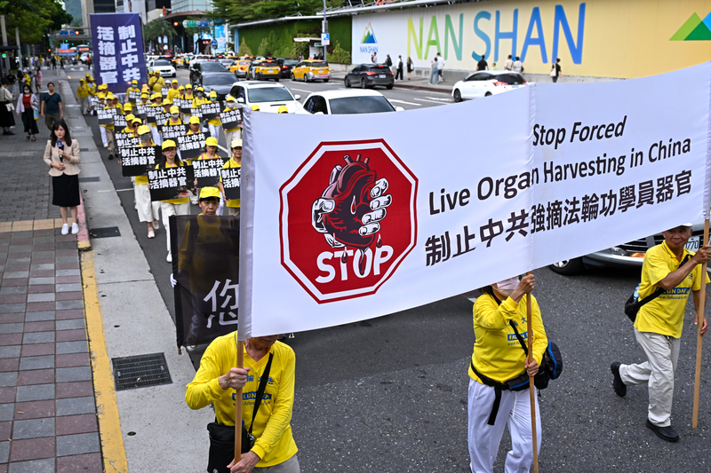 资料图:台北反迫害游行中,参与者举起“制止中共强摘法轮功学员器官”横幅。来源:大纪元