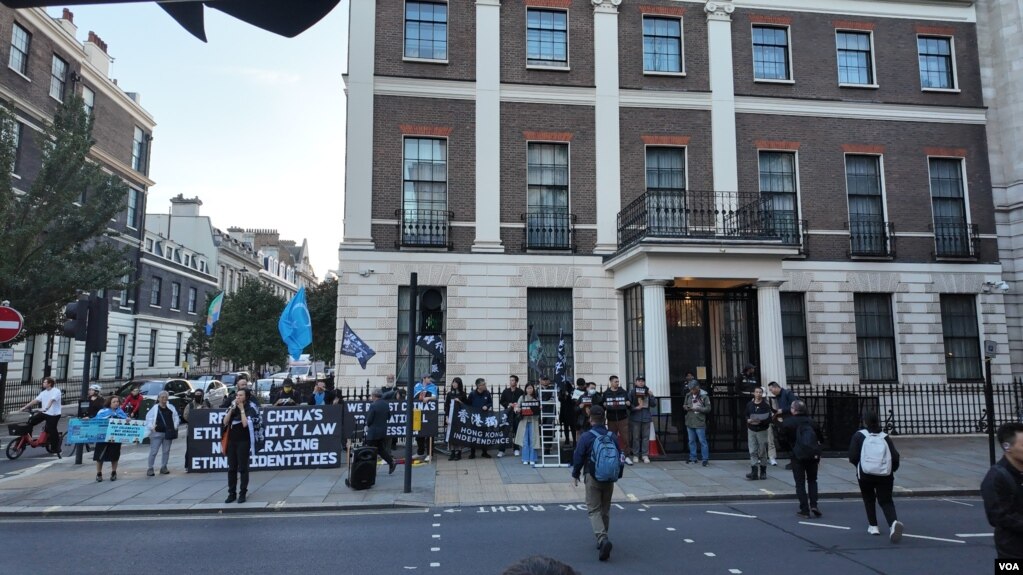 2026年10月1日，示威者在伦敦中国驻英国大使馆外集会，展示声援香港及维吾尔人的旗帜和标语｜来源：美国之音 / 李伯安