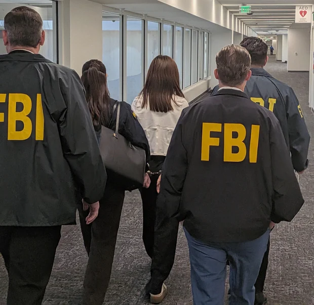 10月4日,FBI探员在洛杉矶国际机场押送被控未登记外国代理人的张婉莹。图片由美国司法部提供|来源:U.S. Department of Justice via CBS News