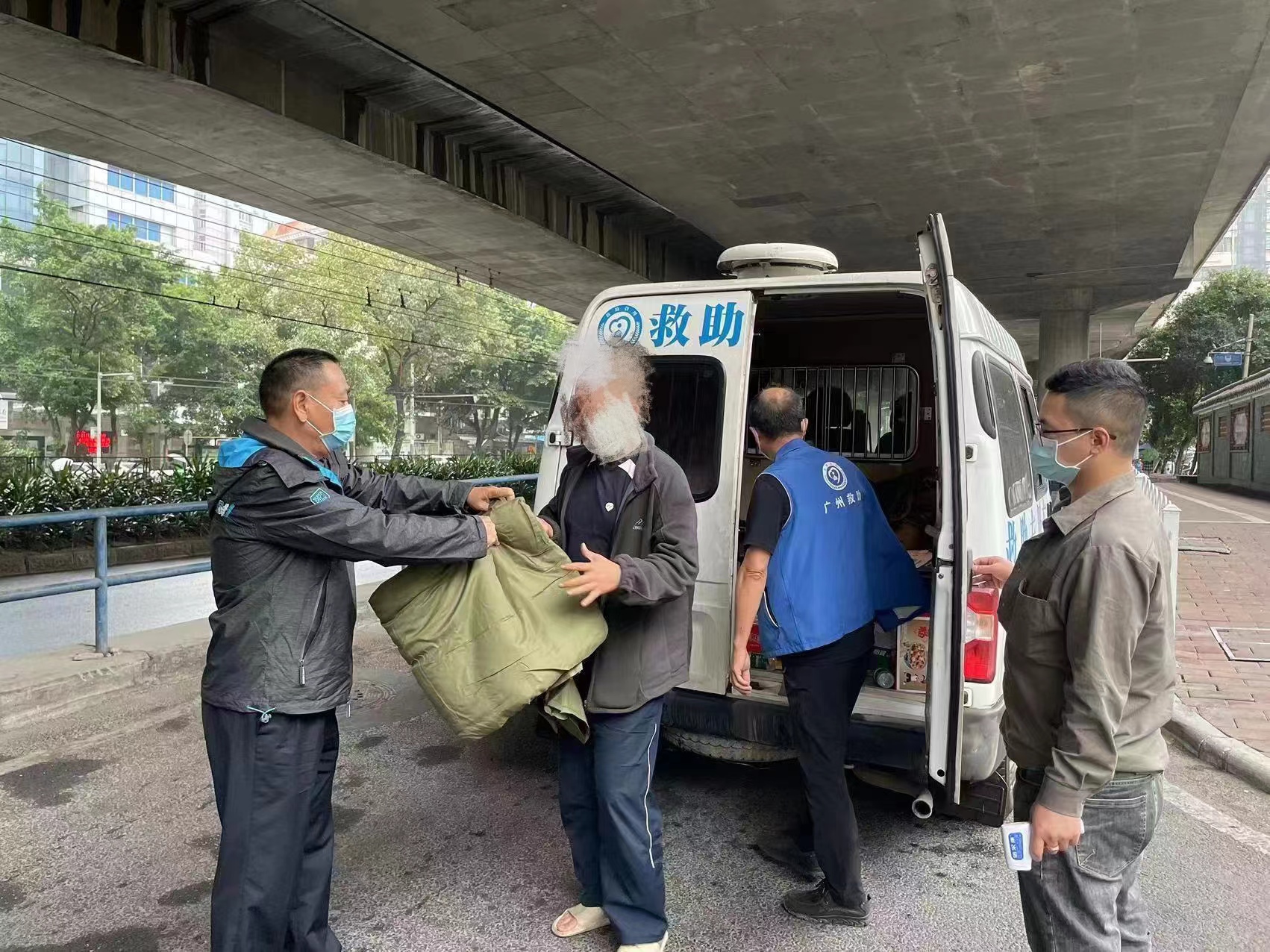 广州流动救助队向街头流浪人员发放御寒物资资料图|来源:广州日报花城